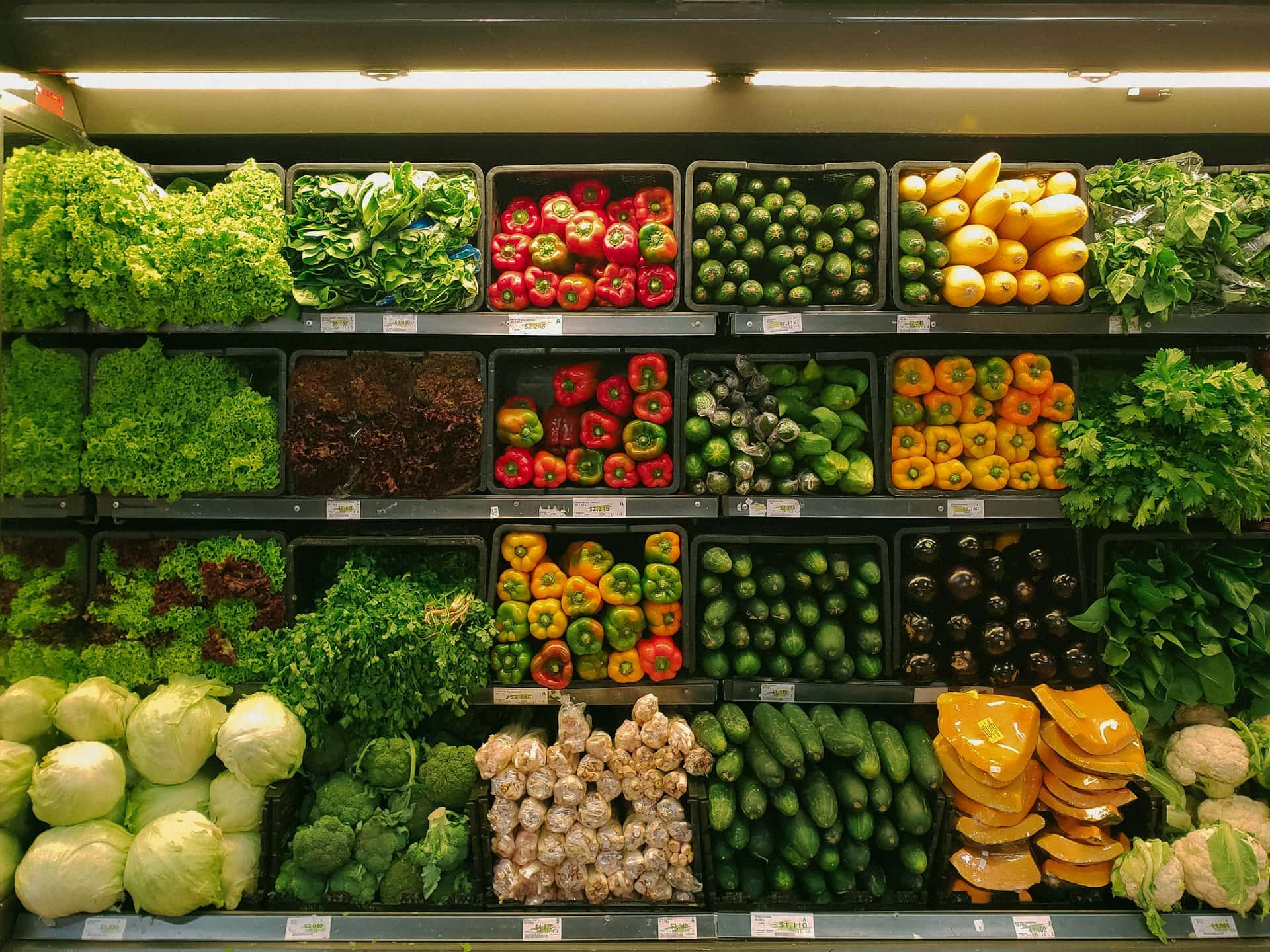 Fresh vegetables and fruits neatly stacked on supermarket shelves