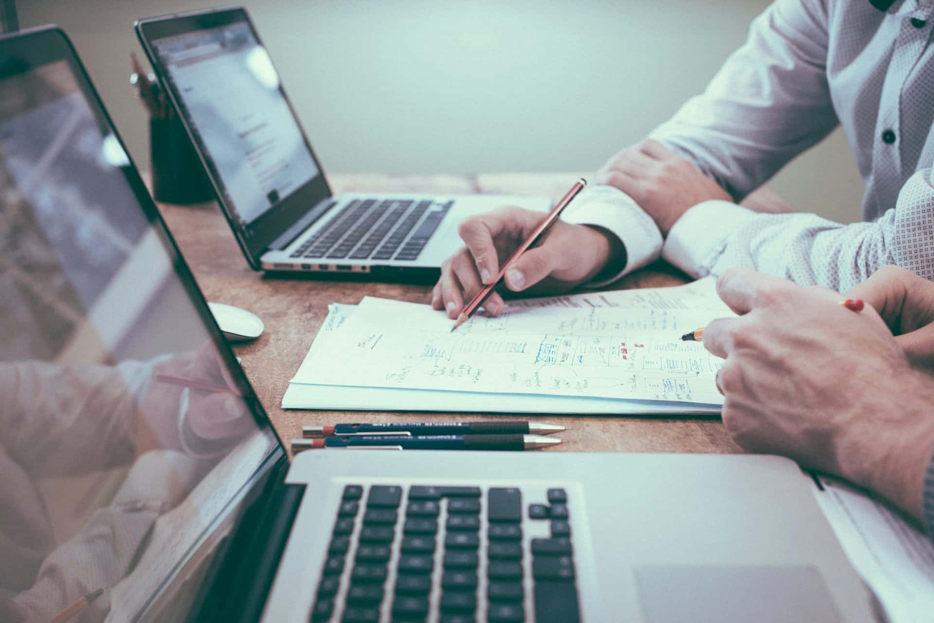 Consultants reviewing documentation and notes on a desk