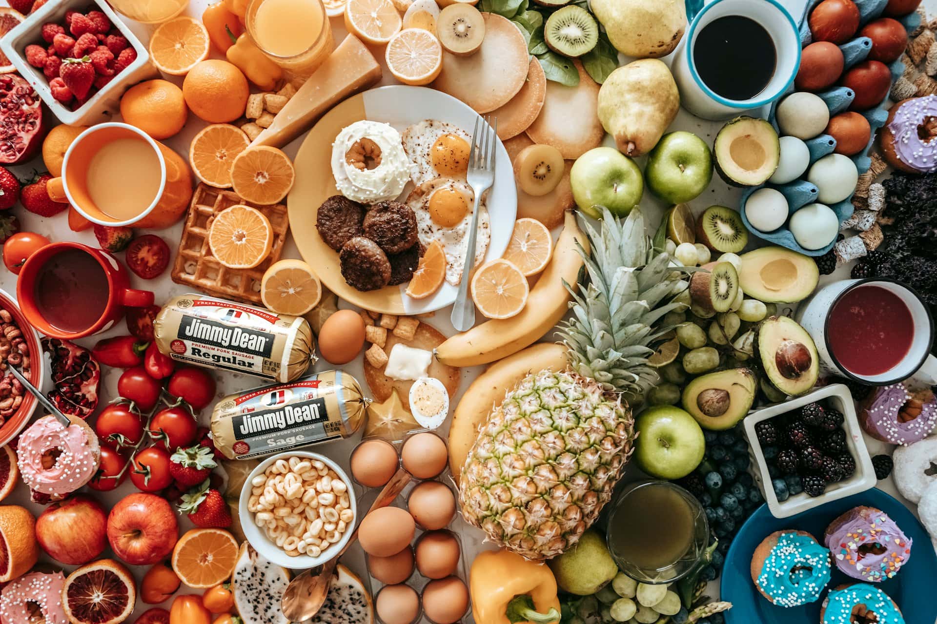 Wide variety of fruits, baked goods and packaged foods laid out on a table