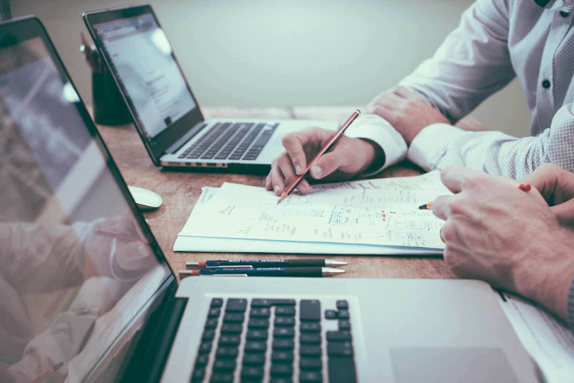 Consultants reviewing documentation and notes on a desk