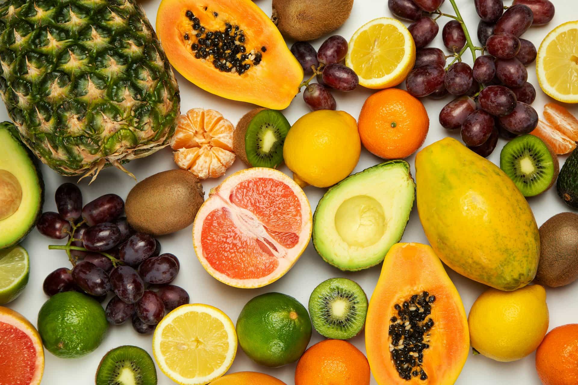 Sliced tropical fruits including papaya, citrus, kiwi and avocado